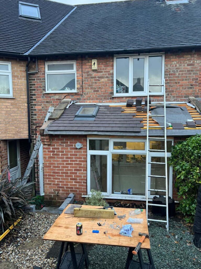 This is a photo of a roof extension that is having new roof tiles installed. This is a photo taken from the roof ridge looking down a tiled pitched roof on to a flat roof. Works carried out by Huntingdon Roofing Repairs