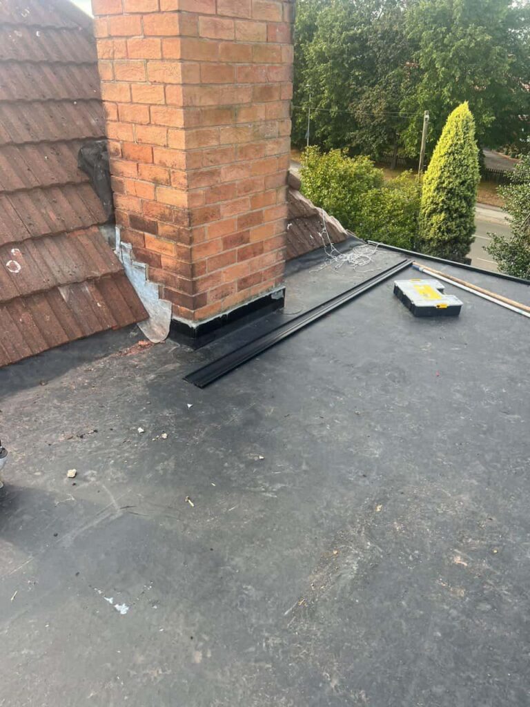This is a photo of a flat roof which has just been repaired, there is also a chimney stack and some leadwork has also been dressed. Works carried out by Huntingdon Roofing Repairs
